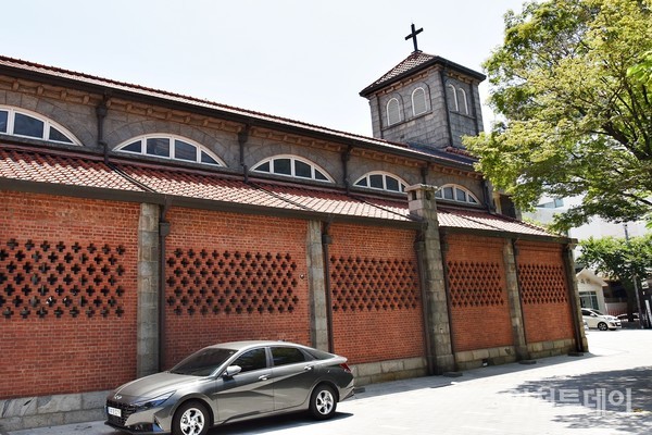 대한성공회 인천내동교회 빨간 벽돌 벽면. 중간에 십자 모양 채광 구멍이 나있다.