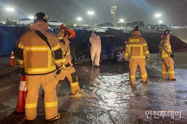 지난 23일 인천 연수구 송도동 소재 공장 주차장에서 소방대원들이 주차장 침수로 고립된 운전자를 구출하고 있다.