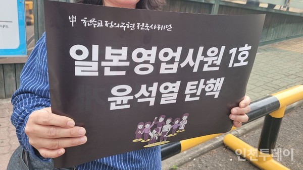 윤석열 퇴진 시국기도회 참여자가 '일본영업사원 1호'윤석열 탄핵' 이라는 문구가 적힌 피켓을 들고 있다.