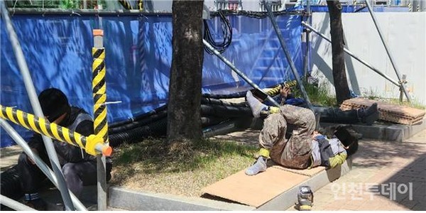 셀트리온 3공장 건설노동자가 지난 5월 휴게공간이 없어 길가에 박스를 깔고 쉬고있다.(사진제공 플랜트노조 경인지부)