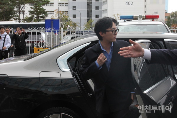 지드래곤이 경찰 조사를 받기 전 기자들의 질문에 답하기 위해 차에서 내리고 있다. 