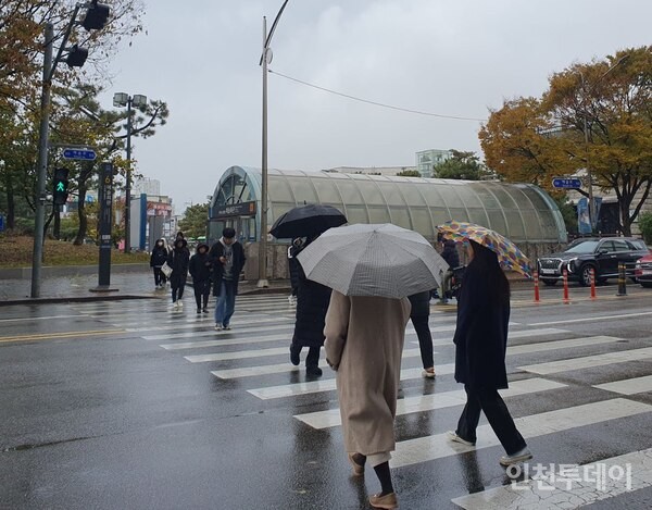 떨어지는 짓눈개비에 사람들이 우산을 쓰고 다니는 모습