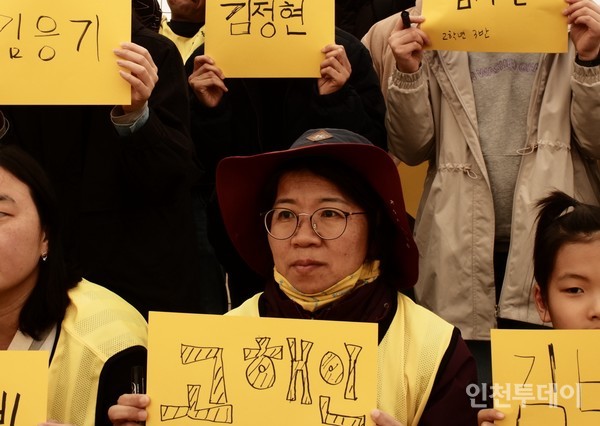 〈다시, 동행〉 참가자 한수진씨가 16일 세월호 참사 피해자의 이름이 적힌 노란 종이를 들고 있다.