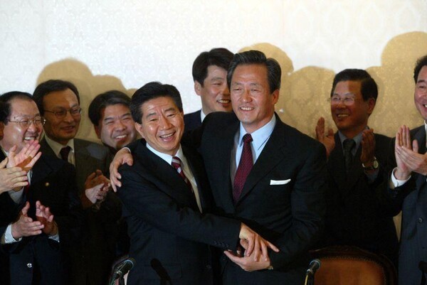 2002년 11월 15일 대통령 후보단일화방식 합의 후 기자회견장에서 포옹하는 노무현 후보와 정몽준 후보.(사진 출처 노무현 사료관)